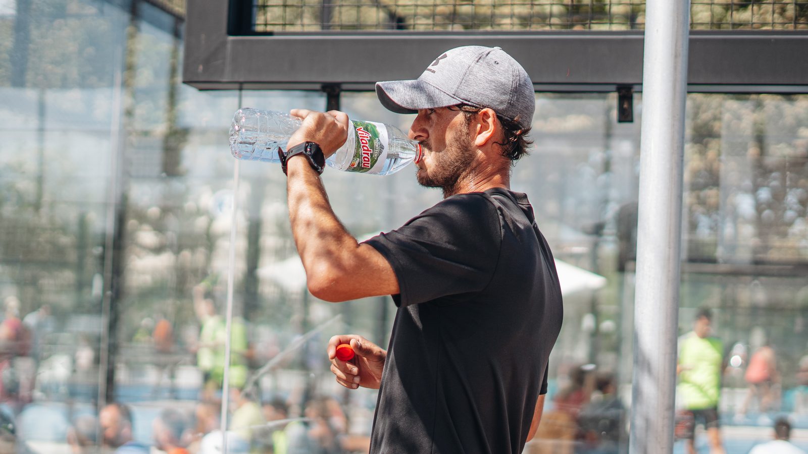 Player rehydrating courtside at a Padel & Go tournament